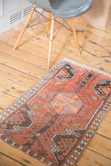 Vintage Oushak rug showing tangerine orange germinating planters and charcoal border.