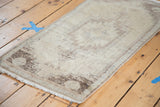Fringed edge and muted neutral guls on a vintage Oushak rug mat.