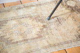 Textured hand-knotted vintage Oushak rug, neutral beige field, charcoal brown pattern.
