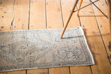 Distressed vintage Oushak rug mat in faded sandalwood, showcasing subtle grey geometric patterns.