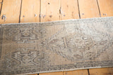 Distressed Oushak rug section with stepped geometric motifs and faded sandalwood tones.