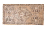 Distressed Oushak rug with faded sandalwood field, grey stepped diamond medallion, and geometric motifs.