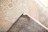 Distressed Oushak rug corner, revealing soft ivory-peach pile and tightly woven backing.