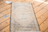 Distressed Oushak hand knotted pile with geometric patterns in faded ivory and peach.