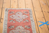 Distressed brick red Oushak rug showing faded quatrefoil and floral motifs.