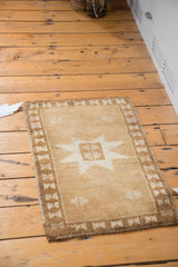 Hand-knotted Oushak rug corner showing rich coffee bronze border with ivory hourglass motifs.