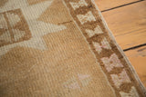Vintage Oushak rug detail: hand knotted bronze field, coffee border, ivory, mauve hourglasses.
