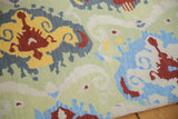 Textured Indian chainstitch weave with vibrant Ikat pattern in saffron, red, and blue.