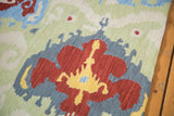 Textured hand-woven chainstitch showing cherry red and saffron yellow Ikat-inspired motif.