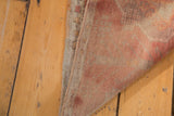 Vintage Oushak rug showing its tightly woven hand-knotted back and beige foundation.