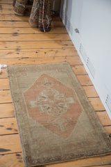 Oushak rug corner detail with stepped medallion and serrated outlines in burnt orange and beige.