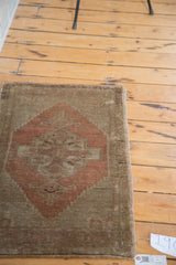 Close-up of hand-knotted Oushak rug edge, burnt orange medallion and bronze pile.