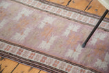 Repeating floral guls in unusual mauve with intricate perimeter details on vintage Oushak rug.