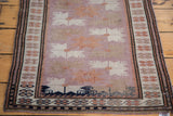 Lower corner of vintage Oushak rug with intricate perimeter details and abraded mauve field.