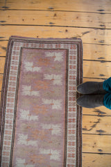 Mauve field, repeating floral guls, and intricate border design of a vintage Oushak rug.