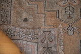 Corner detail of a vintage Oushak rug, showcasing its hand-knotted texture and tribal geometric border.