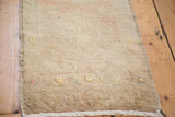 Soft hand-knotted beige pile of the Oushak rug, with saffron yellow accents and fringe.