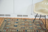 Antique Caucasian rug corner, geometric border and floral motifs in madder red and sky blue.