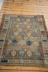 Antique Caucasian rug with geometric motifs, abrash, madder red, sky blue, and bark brown.
