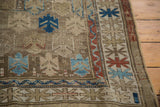 Geometric motifs in bark brown, madder red, and sky blue on an antique Caucasian rug.