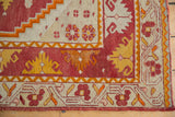 Vintage Oushak rug corner detail, with bold dragon style border in red, yellow, and ivory.