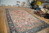 Vintage Heriz carpet, faded cinnabar field, traditional scrolling serrated leaves, navy border.