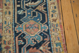 Vintage Heriz rug's side selvage and geometric border in teal, blush, and ivory tones.
