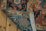 Hand-knotted construction and original selvage of a vintage Heriz carpet with muted colors.