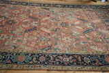 Vintage Heriz carpet detail: blanched red field, scrolling serrated leaves, teal, and worn pile.