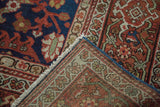 Antique Mahal carpet corner revealing hand-knotted foundation, indigo, rust, and green patterns.