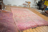 Plush vintage Moroccan carpet, overdyed cranberry mauve and violet, revealing tattered ends.
