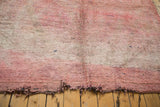Tattered end of a plush vintage Moroccan carpet featuring overdyed cranberry mauve and violet tones.