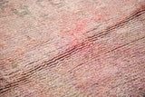 Textural close-up of plush Moroccan wool pile in cranberry mauve and violet overdyed hues.