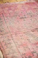 Overdyed cranberry mauve and violet tones on a plush Moroccan carpet with geometric patterns.