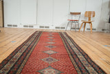 Distressed cherry red Malayer runner with central diamond medallions and paisley design.