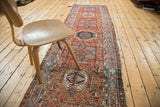 Distressed Karaja runner with geometric diamond medallions, brick red, sky blue, and aged texture.