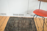 Distressed Oushak square mat featuring bold geometric medallions in chocolate, slate, and beige.