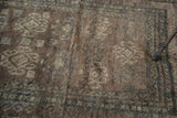 Distressed Oushak rug pile showcasing geometric medallions and a dark, earthy palette.