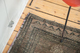 Distressed Oushak rug corner, mauve selvage detail, and dark geometric border.