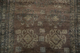 Distressed pile texture of an Oushak rug, showing muted geometric motifs in brown and slate.