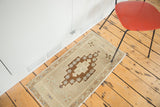 Hand-knotted texture of a vintage Oushak rug, beige field, brown geometric medallion.