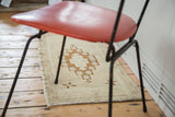Geometric diamond medallion with star floral motifs in sand and bronze tones on a vintage Oushak rug.