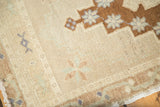 Soft mint and faded blue floral and geometric motifs on vintage Oushak rug's sand field.