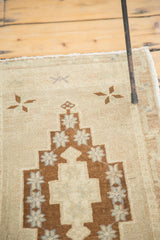 Vintage Oushak rug with brown geometric design and soft floral motifs on hand-knotted pile.