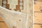 Light beige hand-knotted foundation and brown geometric pile of a vintage Oushak rug.
