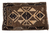 Vintage Oushak rug mat with bold geometric medallions in natural brown, black, and muted beige.