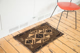 Vintage Oushak rug corner detail, geometric dark brown and beige motifs, secured edge.