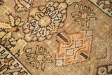 Vintage Oushak rug detail: even pile wear with tribal motifs in natural brown and gold.