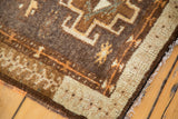 Vintage Turkish Oushak rug corner with intricate geometric patterns and textured brown, beige pile.