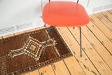 Geometric floral border and white fringe detail on the corner of the vintage brown Oushak rug.